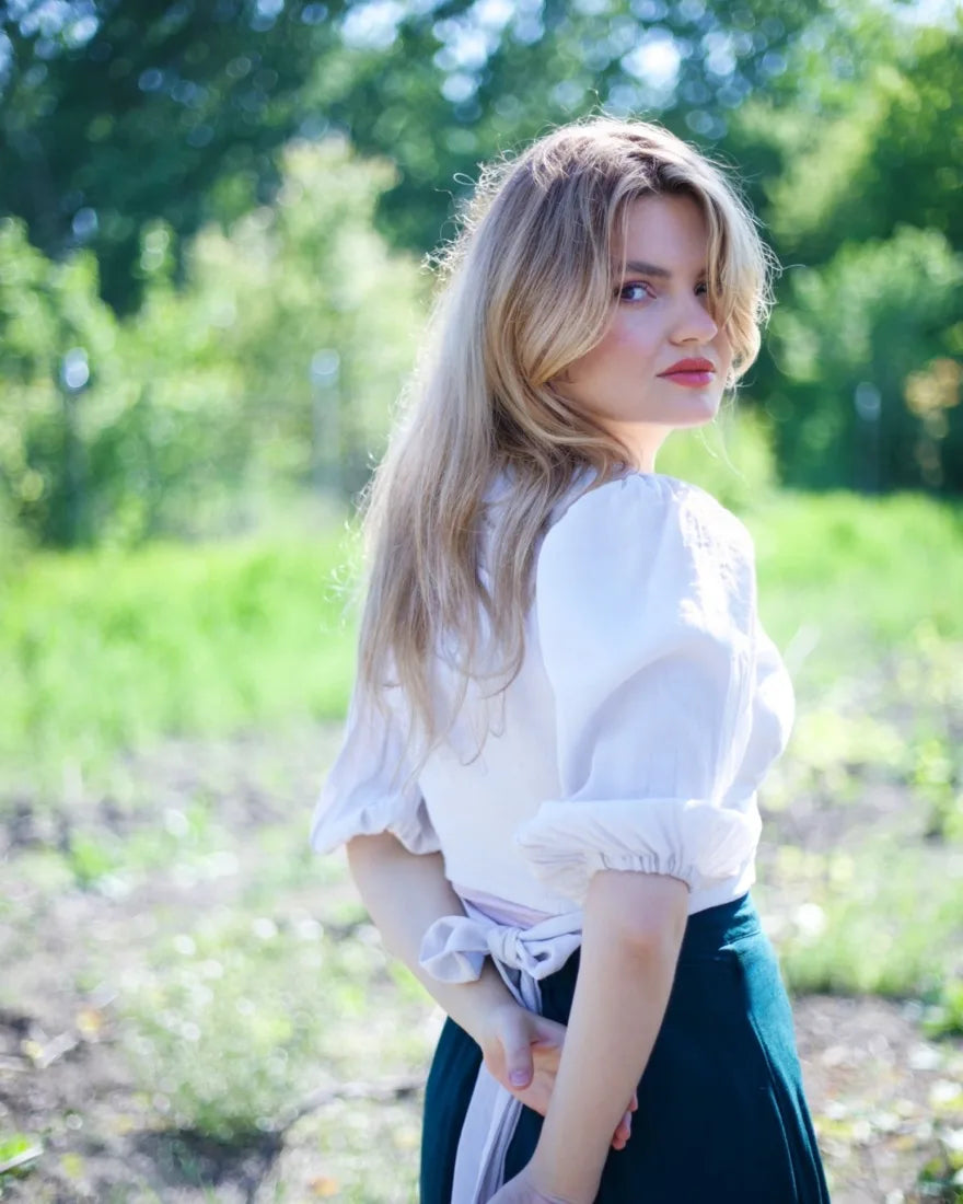 Ruxandra Niță, privind peste umăr, într-o grădină